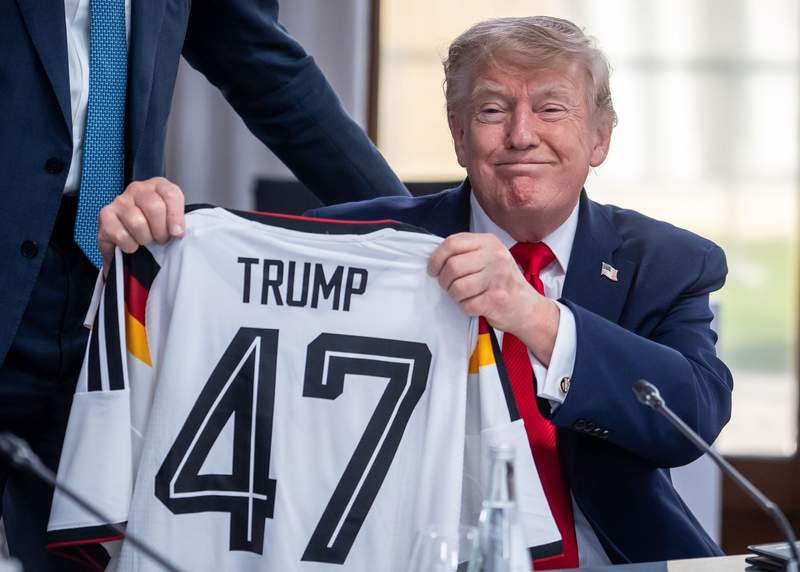 Image from: Muted reaction from Trump as Merz gifts him German team jersey at G7