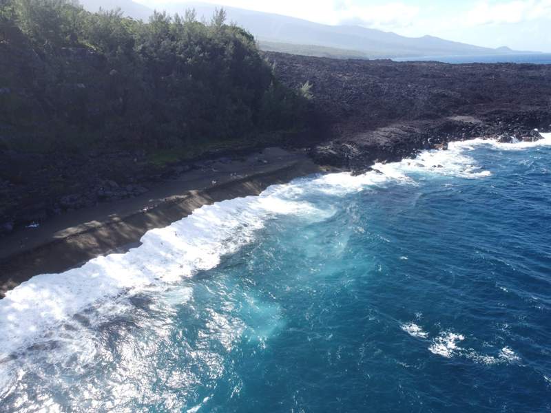 Image from: On Réunion Island, this wild black-sand beach shaped by lava flows offers a spectacular volcanic landscape