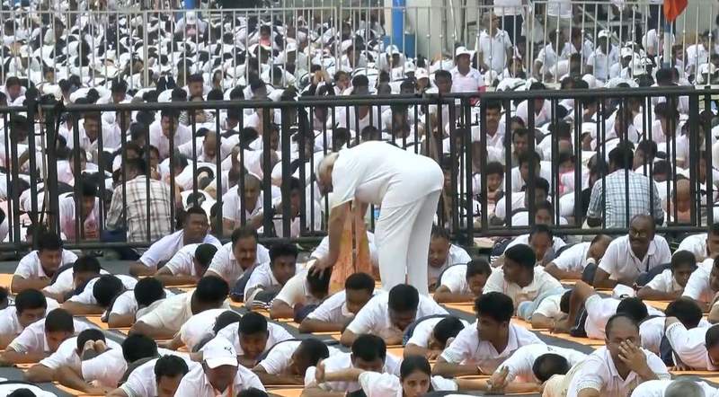 Image from: PM Modi helps participants correct their posture as they perform yoga at IDY celebrations in Kolkata
