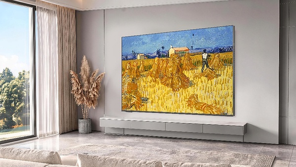 The SKYWORTH C2 Canvas Art TV displays a vibrant painting in a modern living room setting.