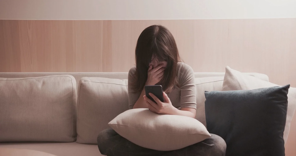woman angry shock phone sitting sofa 123rf