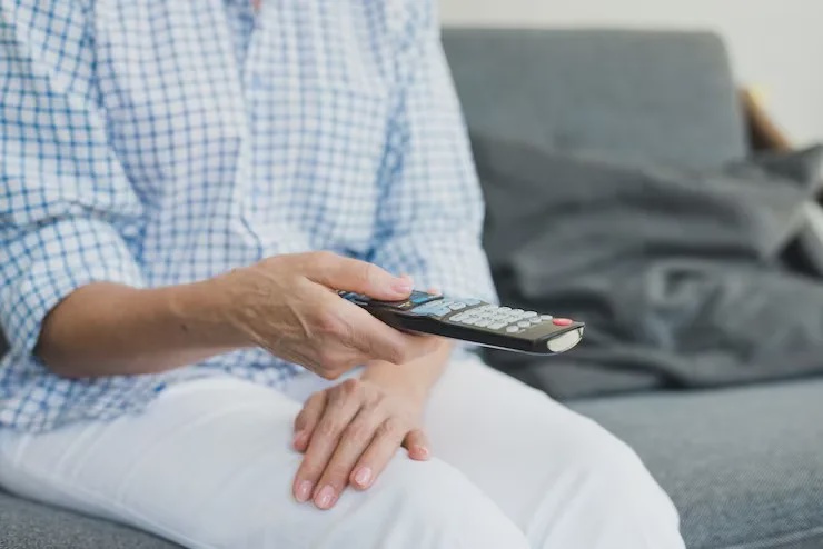 senior woman holding using tv controller magnific