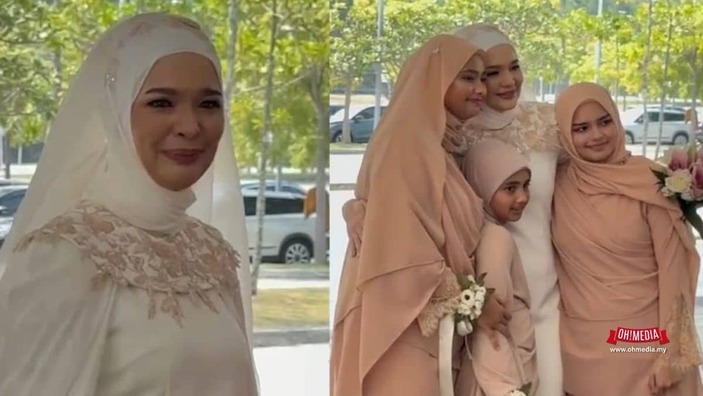 Bride in a white gown with a peach hijab and floral lace, standing outdoors with bridesmaids in peach outfits behind her.