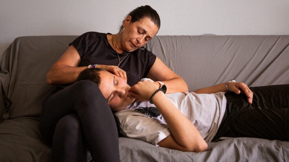 Maria comforts Marcos on a sofa in Madrid during his Airbnb.org Medical Stays booking