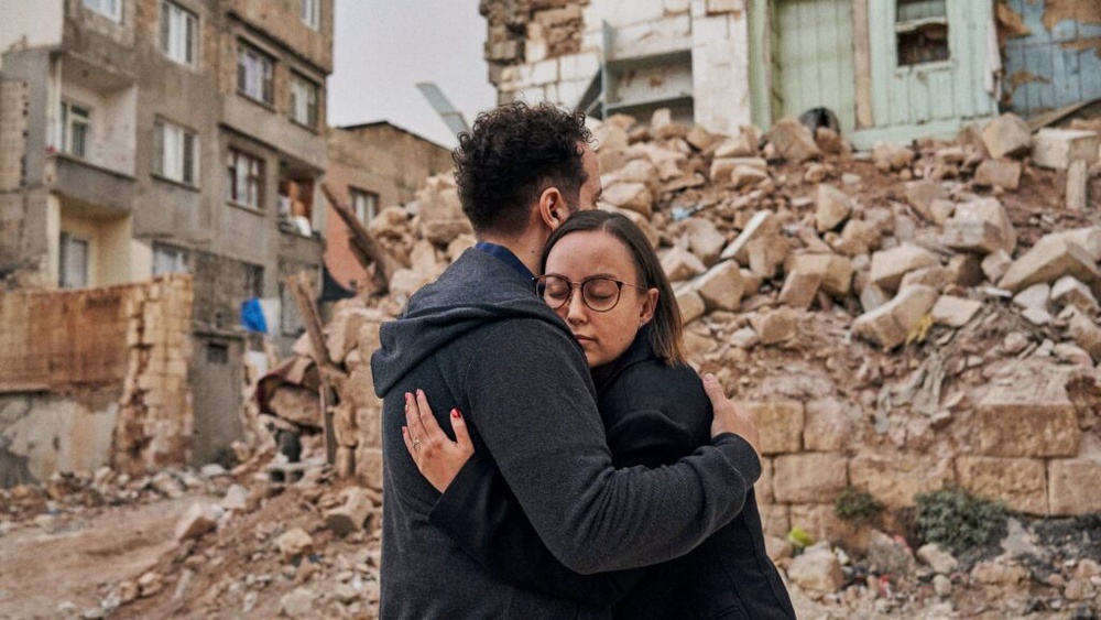 Zehra and Souhel embrace in front of earthquake rubble in Gaziantep, Türkiye, after finding an Airbnb.org stay