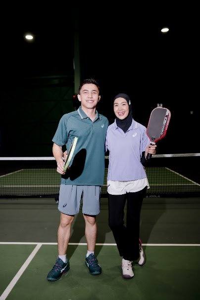 Celebrity couple Harris Alif and Intan Ladyana posing with paddles at World Pickleball Day