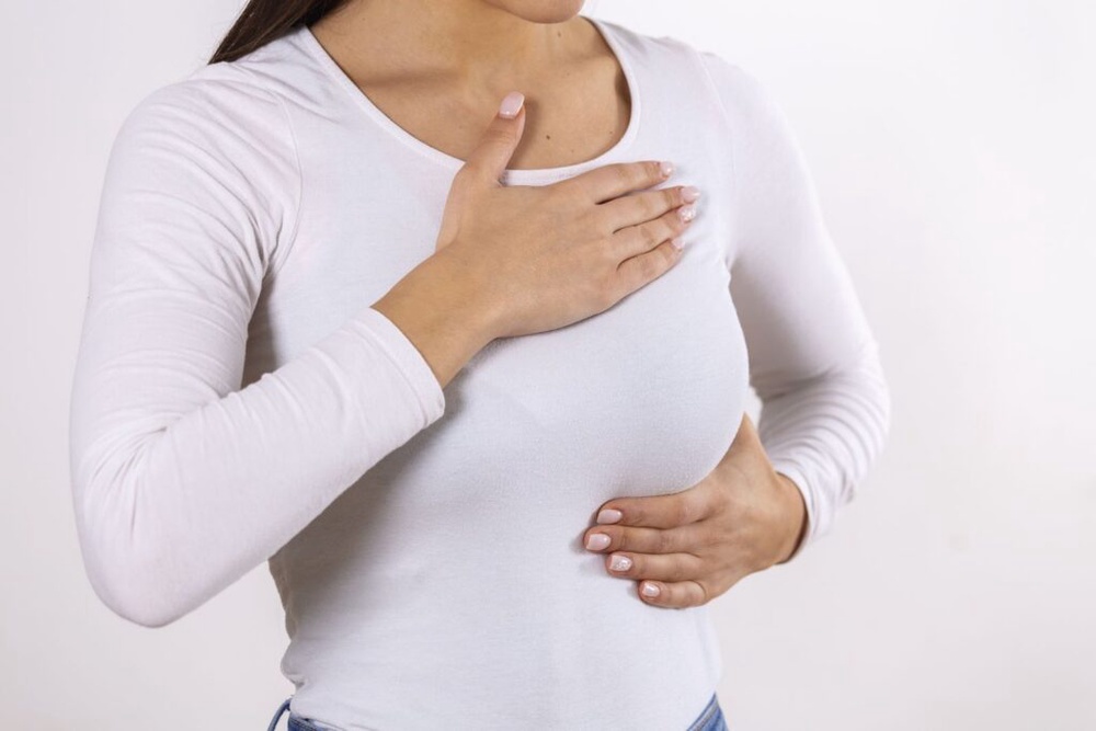 Woman doing a breast self-check for early breast cancer detection