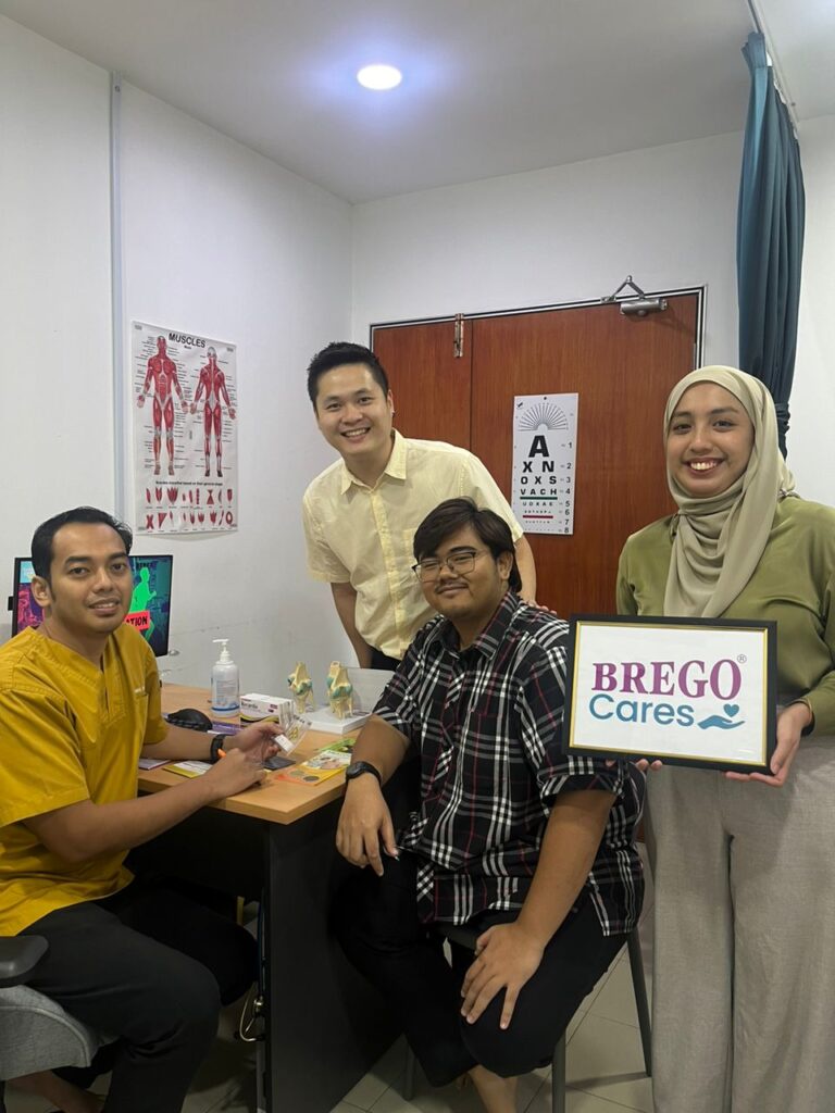 Doctor and participants with a BREGO Cares sign at a primary care clinic consultation room