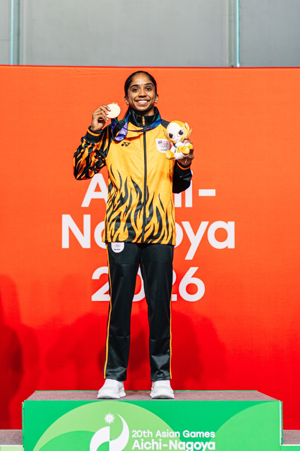 Sivasangari Subramaniam holding her squash gold medal on the podium at the 20th Asian Games Aichi-Nagoya 2026