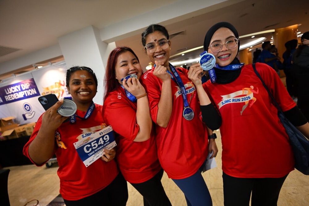 Women participants showing their SJMC Run 2026 medals