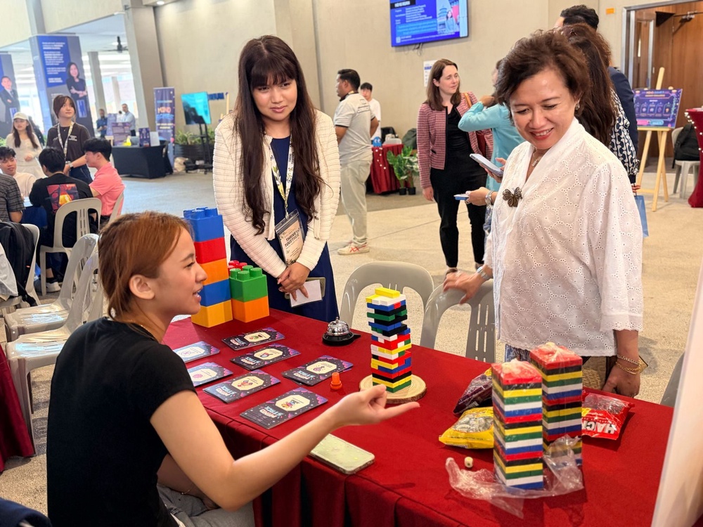 Professor Adeeba Kamarulzaman visiting a student wellbeing exhibition booth at Thrive Together 2026