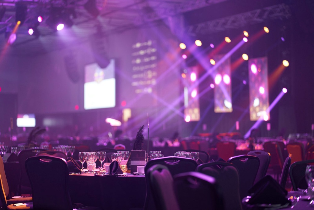 Gala dinner set-up with round tables and purple stage lighting for a W Kuala Lumpur event
