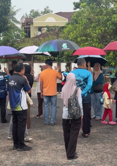 Image from: Tak Mahu Anak Basah Kena Hujan, Ibu Bapa Gabung Payung Iring Naik Bas