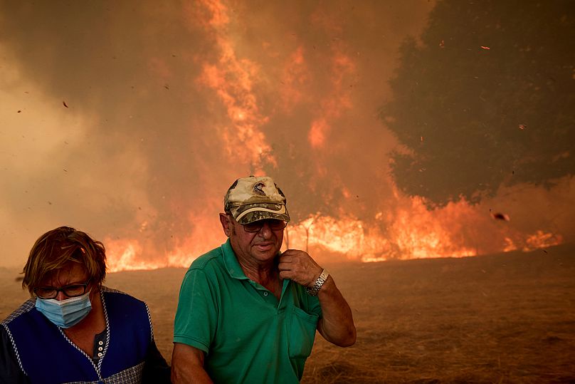 Residents battle a wildfire advancing toward Rebordondo village, near Ourense, in northwestern Spain, on Monday, Aug. 18, 2025.