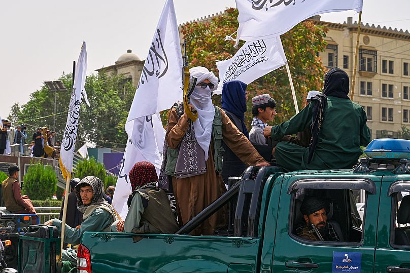 Taliban fighters and supporters ride on a pickup truck during celebrations marking the anniversary of the US withdrawal in Kabul, 15 August, 2025