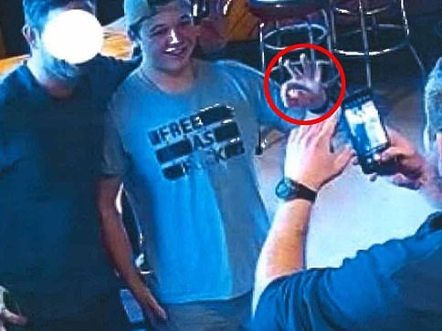 Kenosha shooter Kyle Rittenhouse at a bar in Wisconsin making a hand symbol that has been associated with white supremacists, internet trolls, militias and the word “ok.