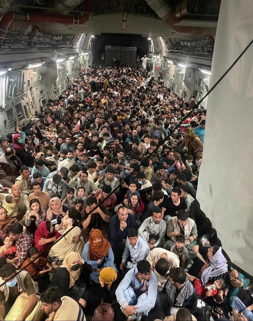Afghans fleeing Kabul are crammed inside a US Air Force cargo plane headed to Qatar on 15 August 2021 (AFP via Getty)