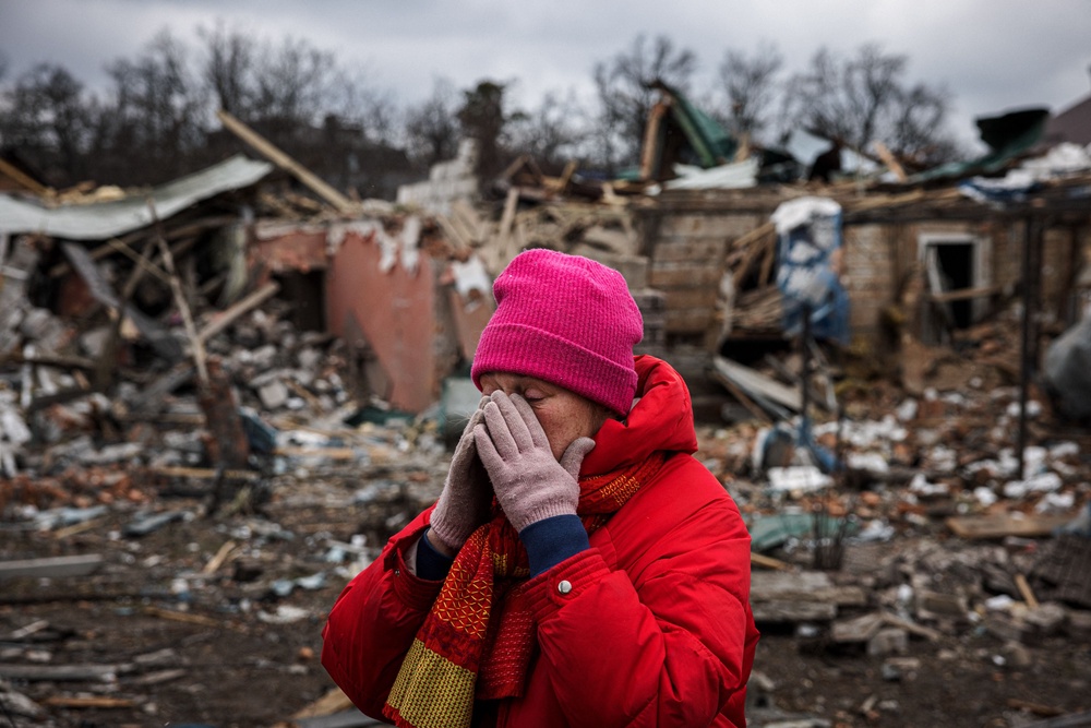 Irina Moprezova, 54, reacts in front of a house that was damaged in an aerial bombing in the city of Irpin, northwest of Kyiv, on 13 March 2022 (AFP/Getty)