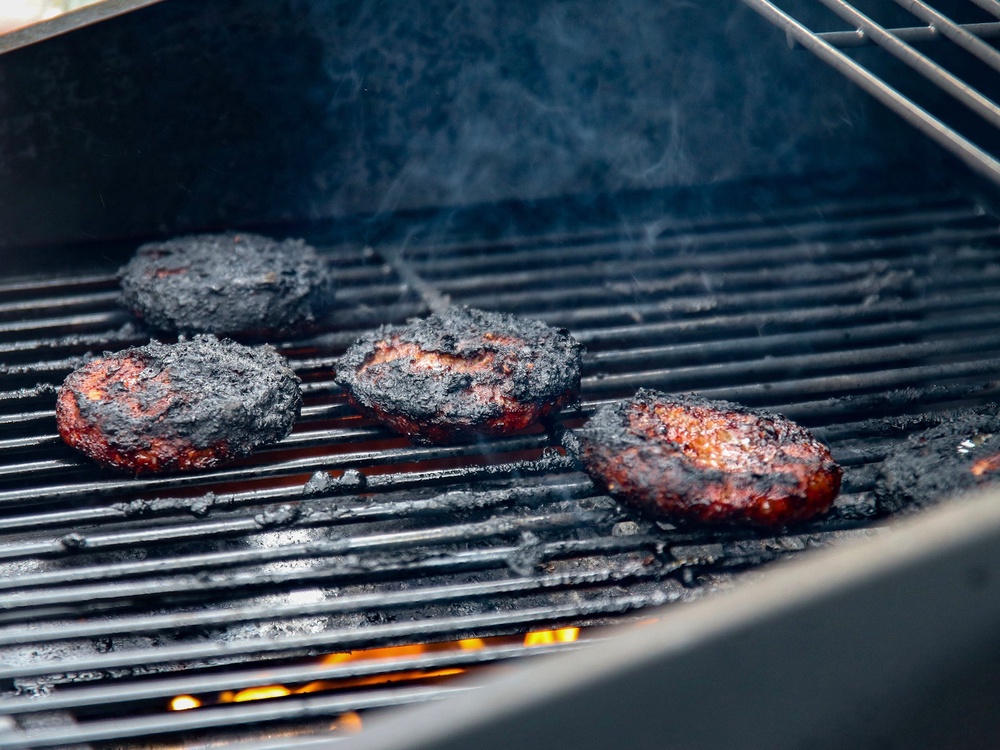 Placing cooked burgers back onto the tray that previously held raw ones, can also spread bacteria (Getty/iStock)
