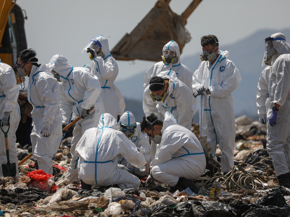 Hong Kong police officers comb through garbage for the remains of murdered model Abby Choi on 28 February 2023 (Jerome Favre/EPA)