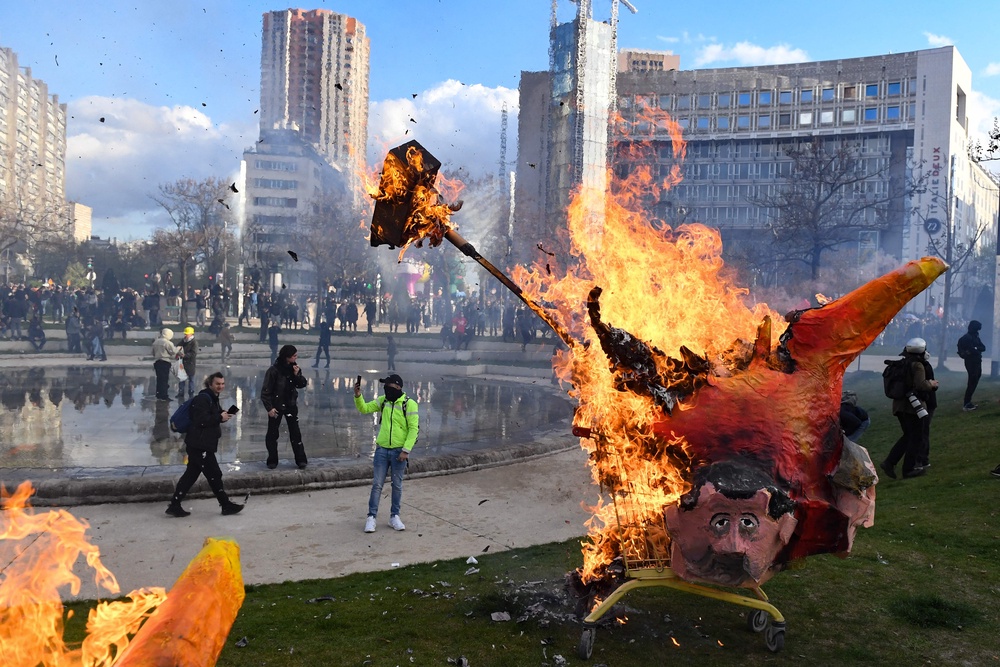 An effigy of French President burns during a demonstration at Place d'Italie, on the 11th day of action after the government pushed a pensions reform through parliament without a vote, using the article 49.3 of the constitution, in Paris on April 6, 2023 (AFP/Getty)