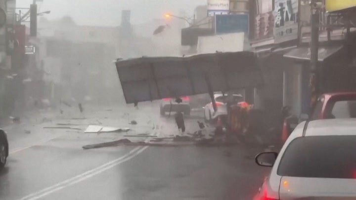 Debris blown down road as Typhoon Koinu brings violent, record-breaking ...