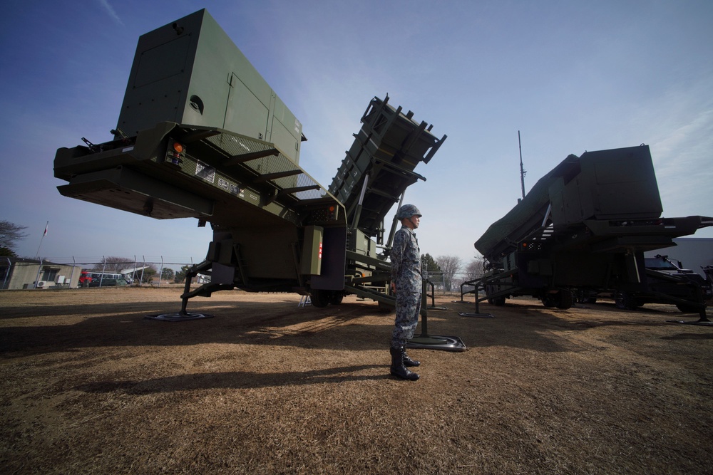 A member of the Japan Ground Self-Defense Force stands guard next to a surface-to-air Patriot Advanced Capability-3 (PAC-3) missile interceptor launcher vehicle in Funabashi, east of Tokyo, on Jan. 18, 2018 (Copyright 2018 The Associated Press. All rights reserved.)