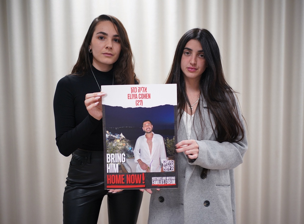 Ziv Abud (right) and friend Michal Rahoom hold a poster of Eliya Cohen while raising awareness of his plight in London in January 2024 (PA)