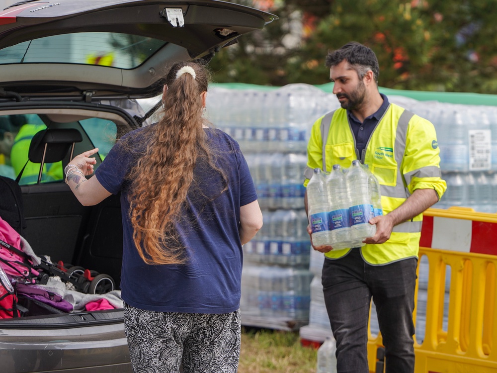 South West Water staff and volunteers distribute water to the public at a water collection point in Brixham (Getty Images)