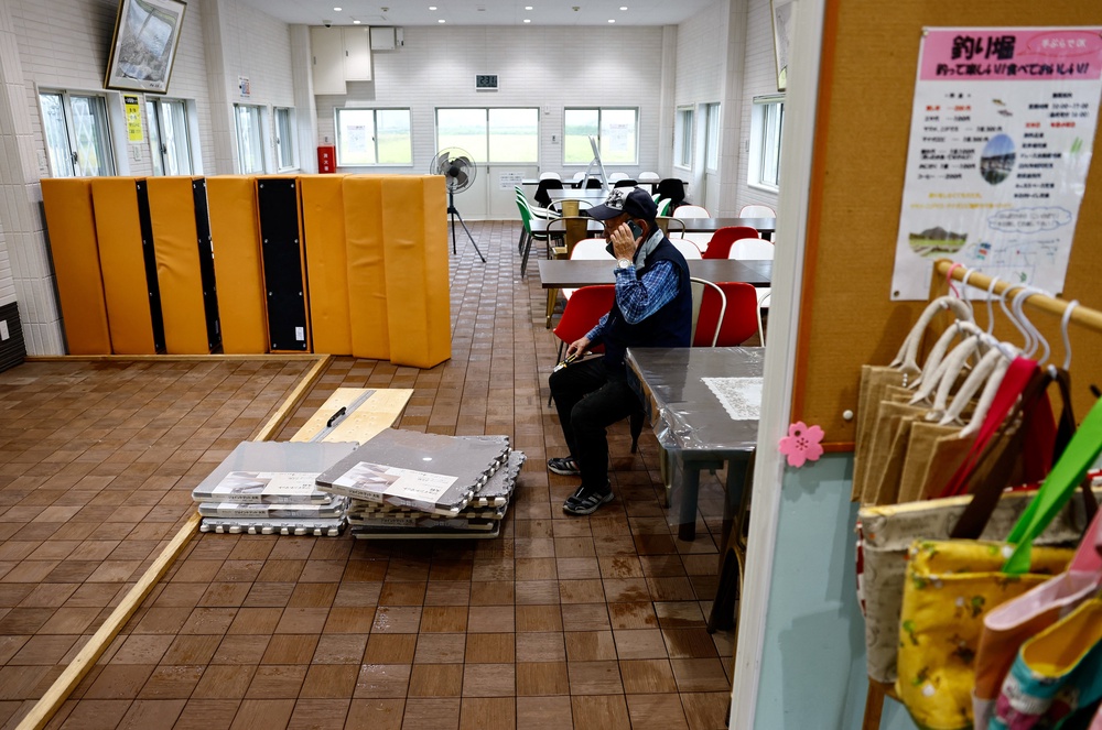 A man pauses while cleaning the floor at a fish farm, after the facility was flooded during Typhoon Shanshan in Yufu (REUTERS)