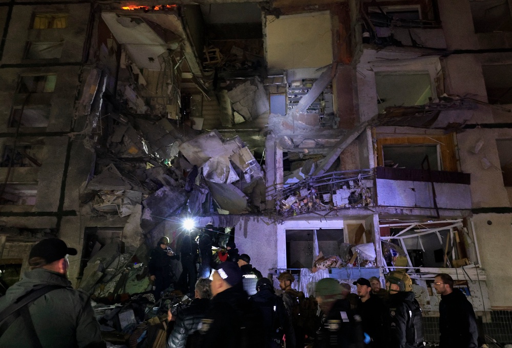 Ukrainian rescuers working at the site of a Russian glide-bomb attack late at night on a nine-floor residential building in Kharkiv (EPA)