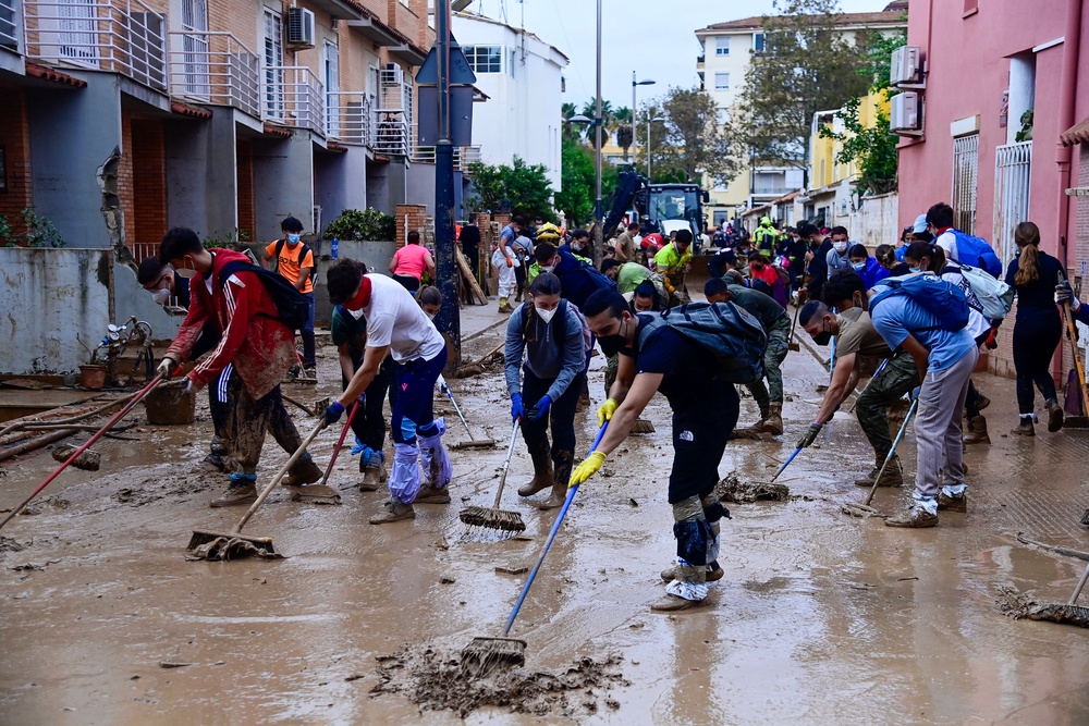 People clear mud from a street in Alfafar, in the region of Valencia, eastern Spain (AFP via Getty Images)