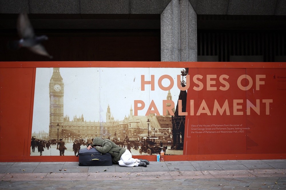 A rough sleeper lies on a suitcase in central London (AFP via Getty Images)