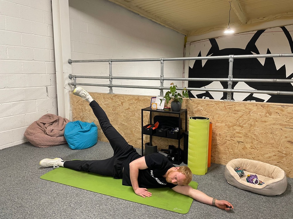 The Independent's fitness writer Harry Bullmore performing a side leg raise (Harry Bullmore / The Independent)