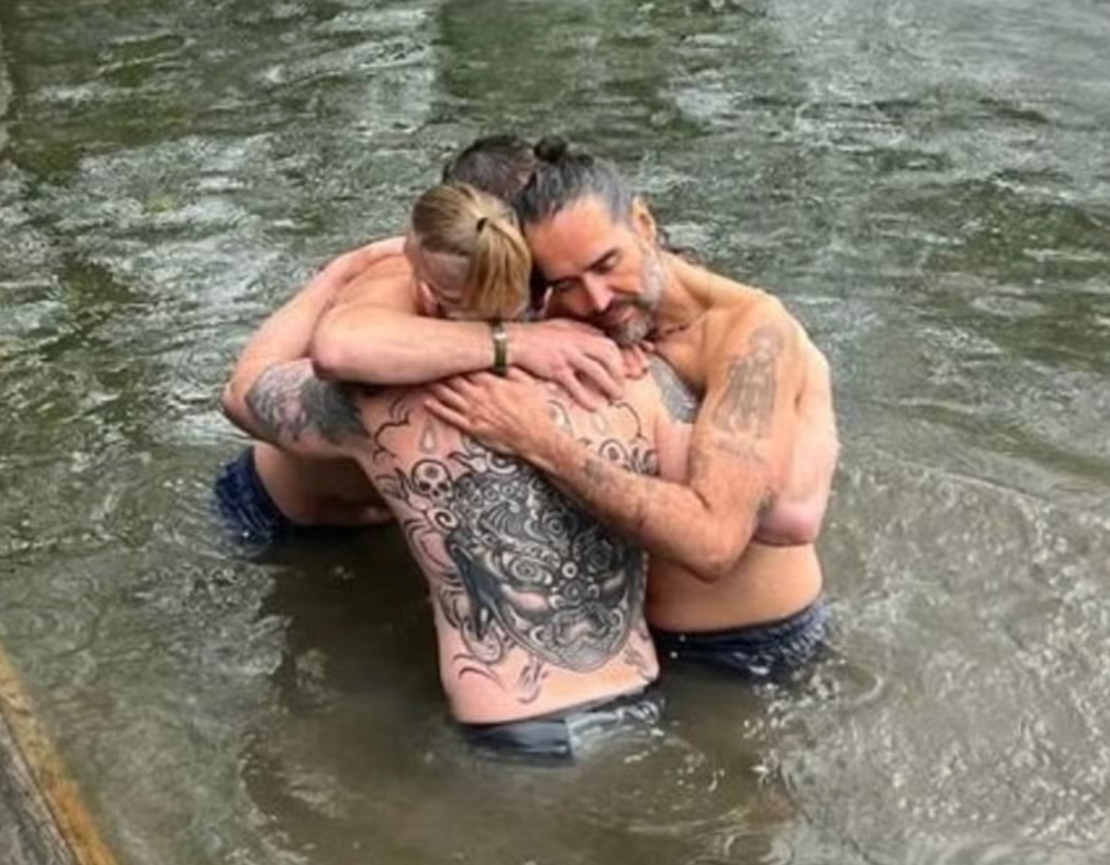 Bear Grylls and a third man hug Russell Brand after he's baptised in River Thames (Instagram)