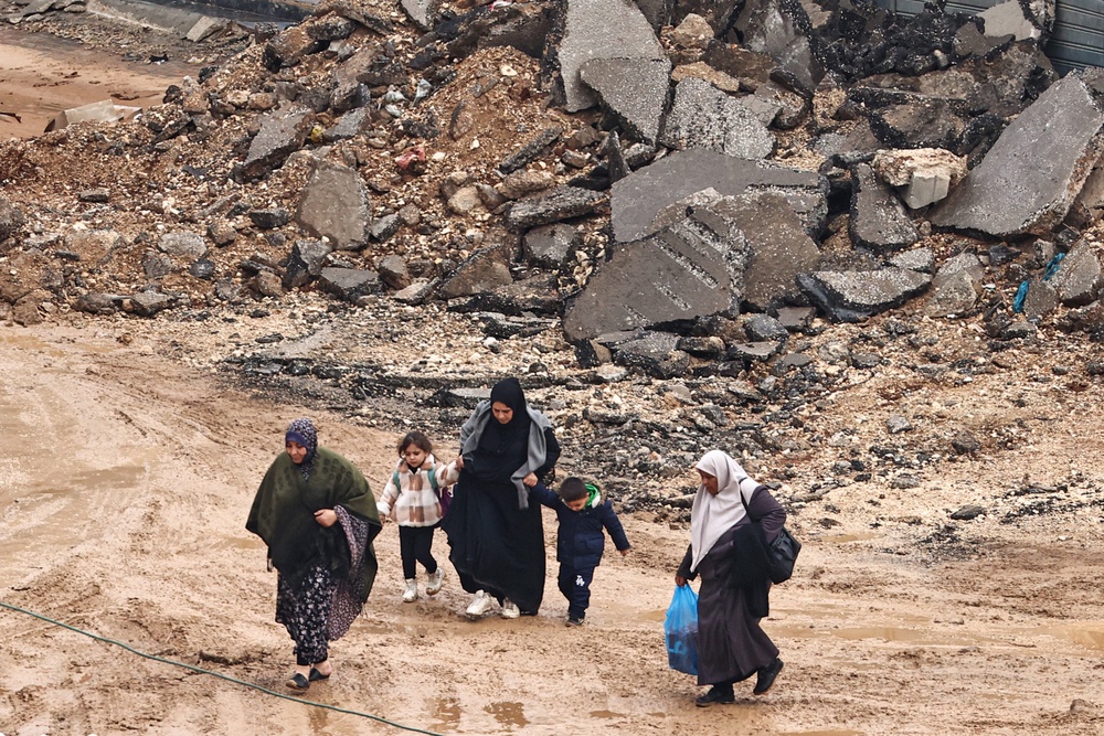 Palestinian women and children walk in the mud as they leave for safety during an Israeli army raid in al-Faraa refugee camp near Tubas (AFP via Getty Images)</div></div></div><div class=