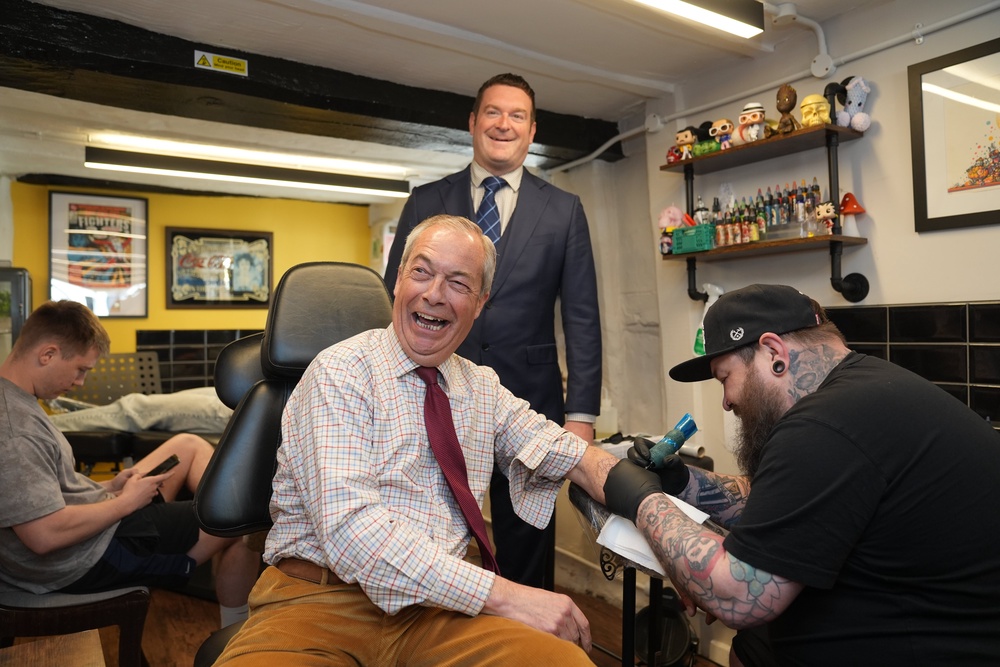 Reform UK leader Nigel Farage and Reform UK mayoral candidate Ryan Coogan visit a tattoo parlour during Reform UK's local election campaign (Joe Giddens/PA Wire)