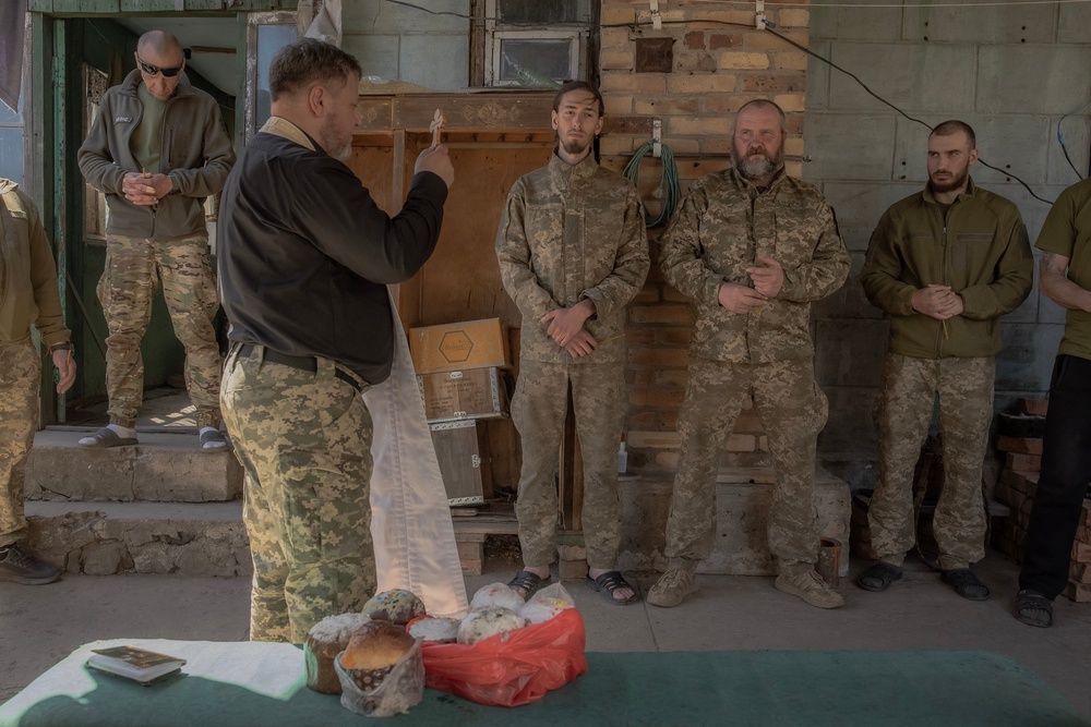 A military chaplain blesses Ukrainian servicemen of the 100th brigade and traditional cakes to celebrate Orthodox Easter, in the Donetsk region (AFP via Getty Images)
