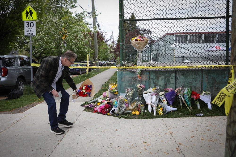 A person places flowers at a make-shift memorial where a car-ramming tragedy took place during a Filipino festival in Vancouver, British Columbia (EPA)