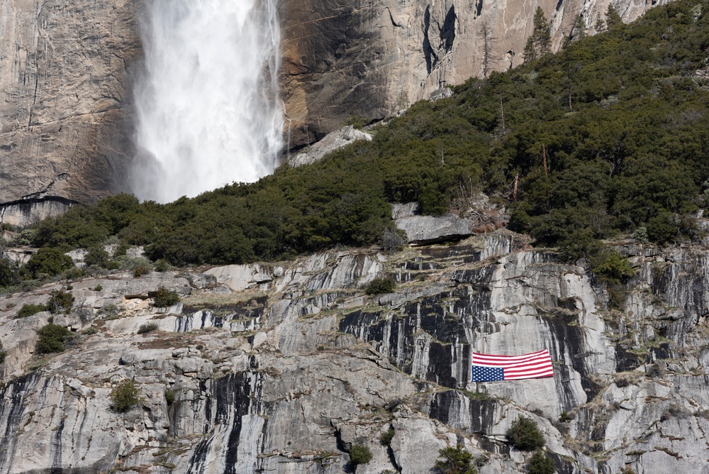 A US flag is hung upside down below the Upper Yosemite Falls during a protest against federal employee layoffs at Yosemite National Park, California on March 1, 2025. (AFP via Getty Images)