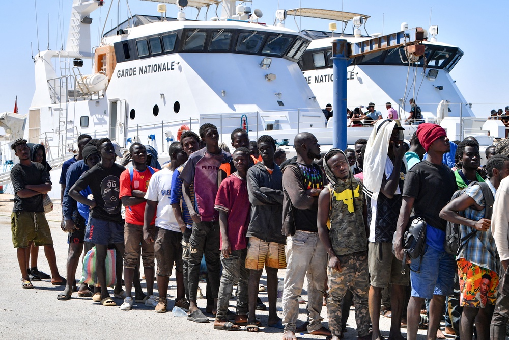 Migrants trying to flee to Europe, disembark in Sfax from a ship owned by the Tunisian coastguards, after being intercepted by them at sea on 10 August 2023. (AFP/Getty)