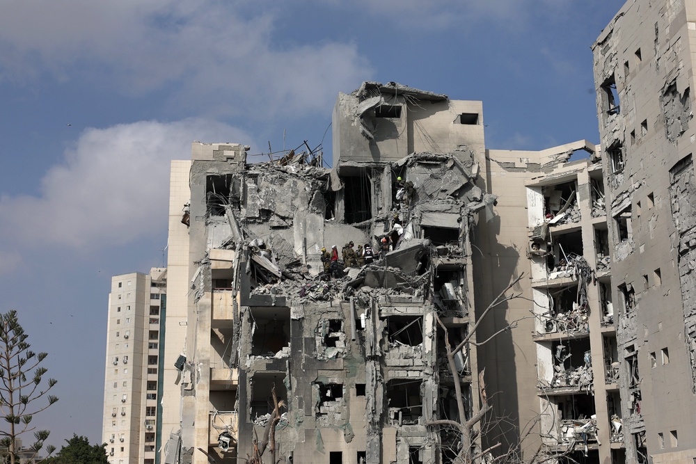 Israeli rescue teams work at the site of a missile strike on a residential area in Be'er Sheva, southern Israel on Tuesday (EPA)