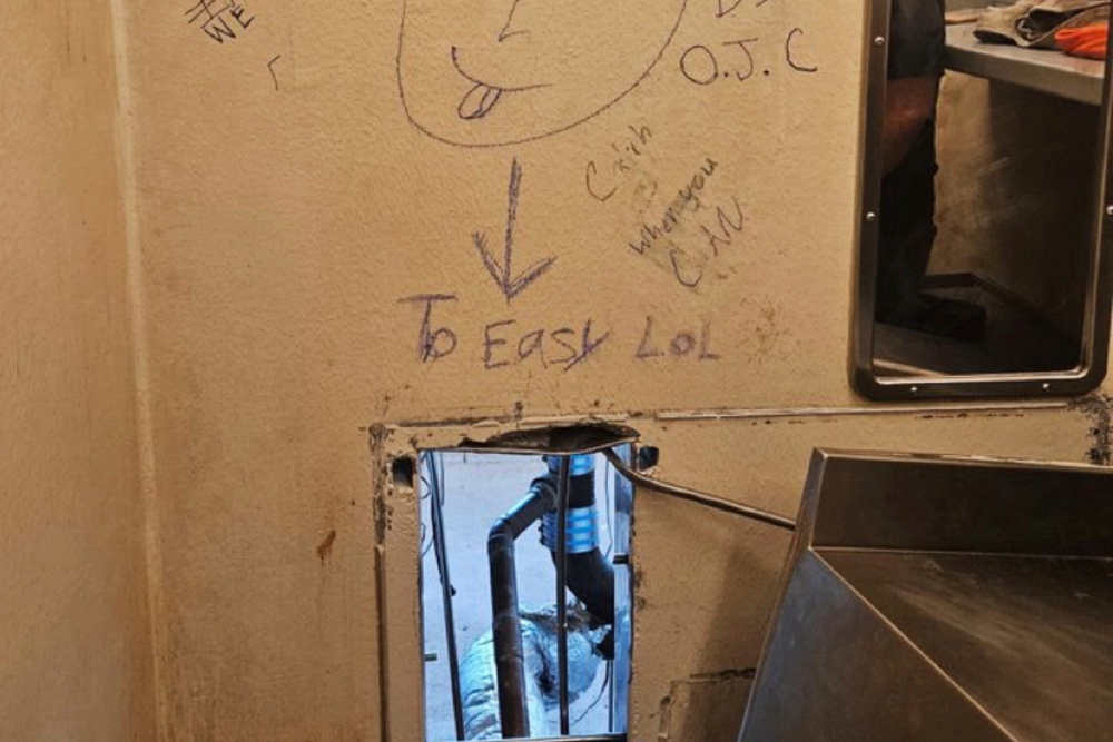 Taunting graffiti is seen around the hole that 10 inmates used to escape a New Orleans jail in early on May 16, 2025 (Local Library)