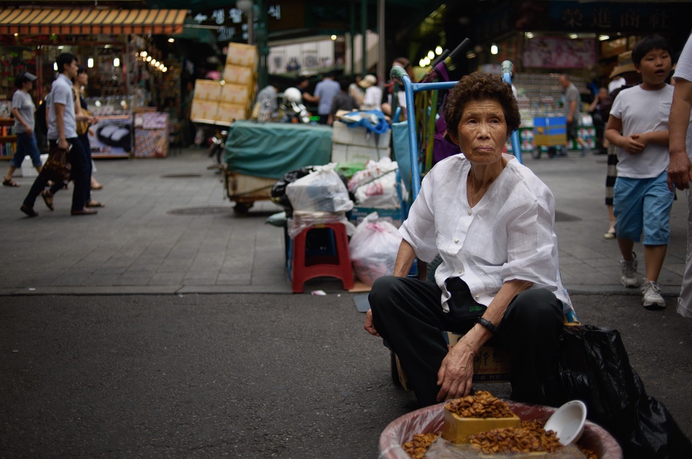 A South Korean vendor sits before a bowl of 'beondegi', or boiled silkworm pupae (AFP/Getty)