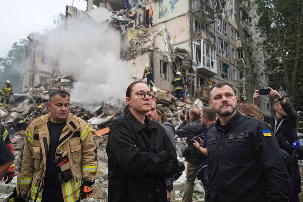 Ukraine's prime minister Yuliia Svyrydenko and interior minister Ihor Klymenko visit the site of a multi-storey residential house destroyed by a Russian missile attack in Kyiv (AP)