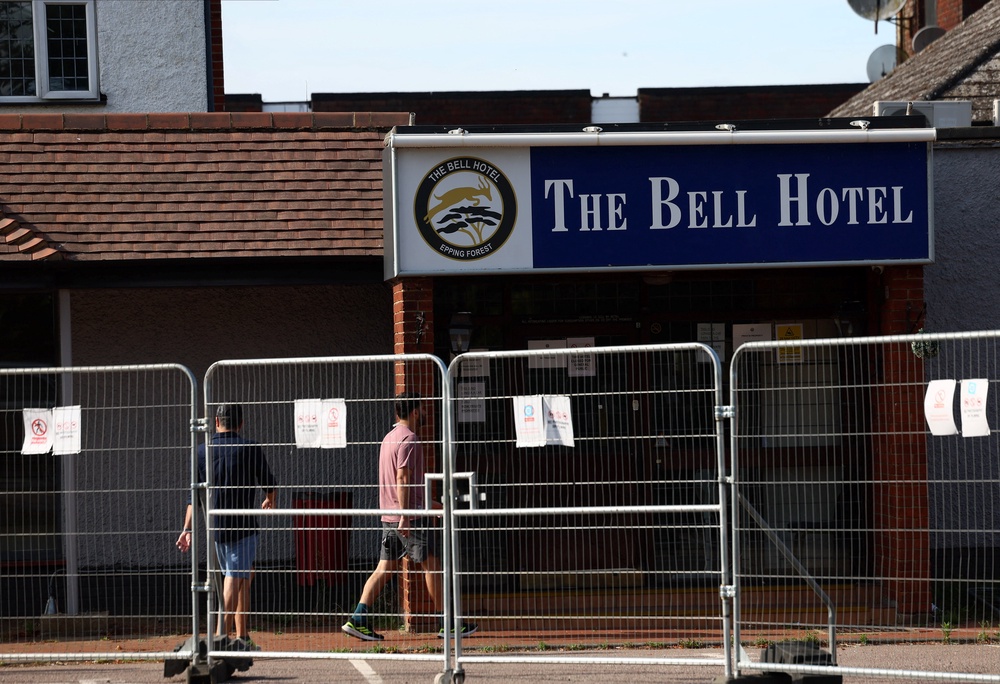 Men pictured walking into The Bell Hotel, which has been housing asylum seekers (Reuters)