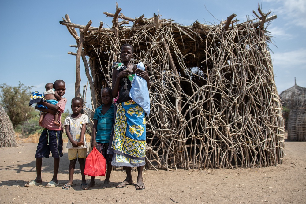 A family is photographed in front of their house during the devastating drought that hit Turkana, Kenya, last year. The country is set to set to see its UK aid fall from £79.5m to £5m over four years. (Save the Children)