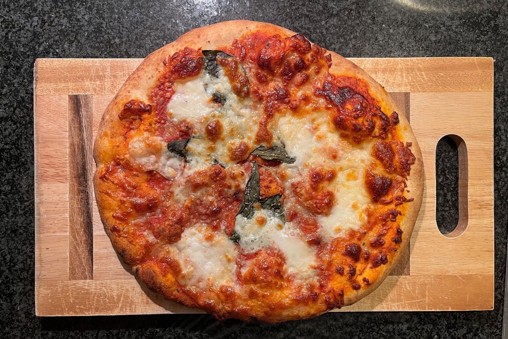 This is finished with fresh basil and mozzarella balls (Alice Reynolds/The Independent)