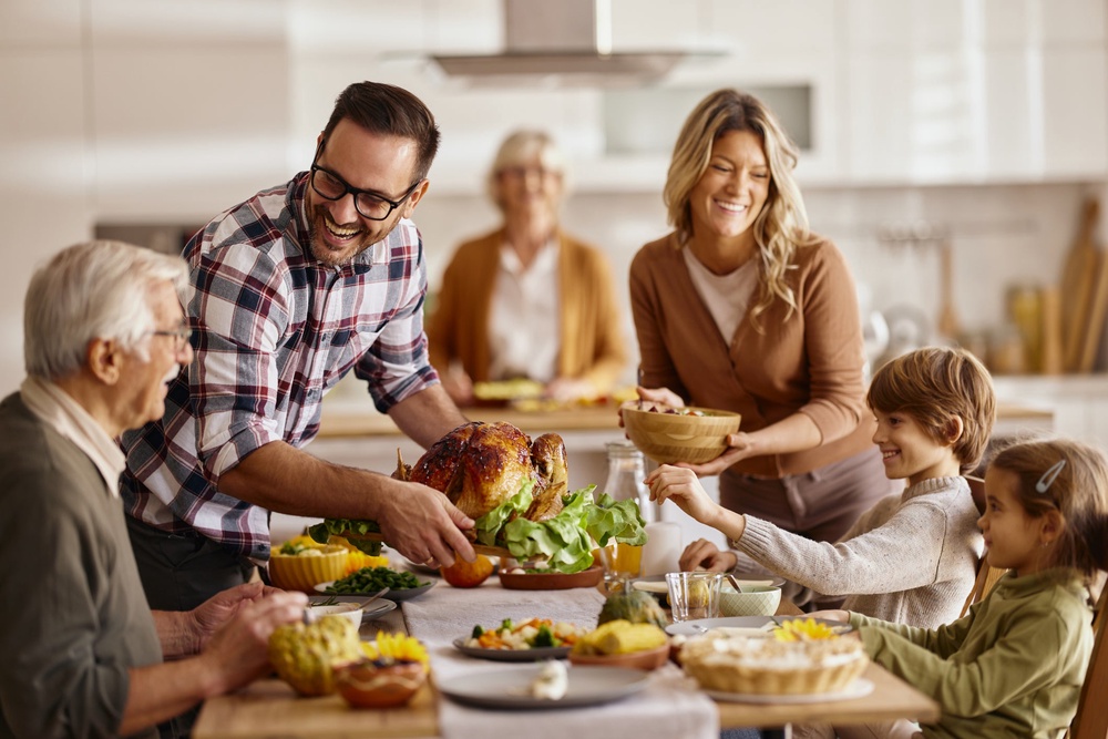 Family sitting down for Thanksgiving dinner (Getty)