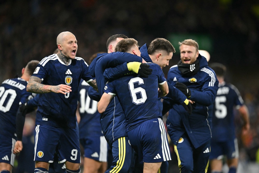 Scotland players celebrate on the pitch after the World Cup 2026 qualification match against Denmark on 18 November (AFP via Getty Images)